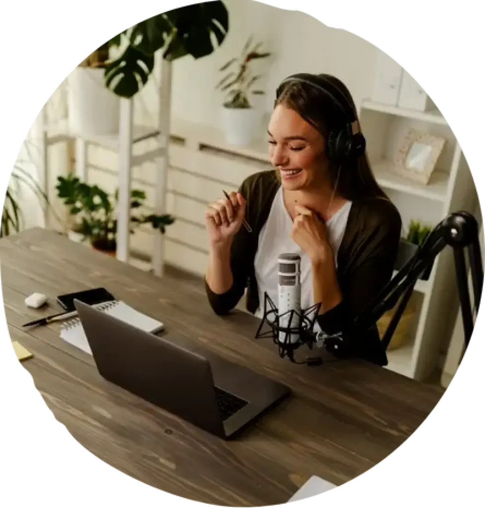 Podcaster recording audio using a microphone and laptop setup