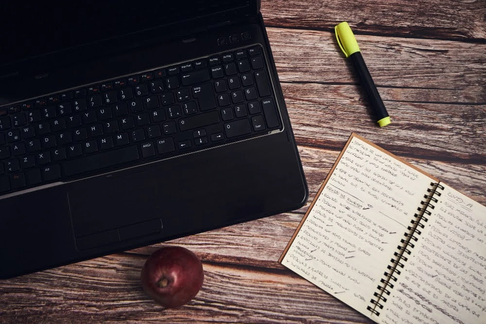 Laptop and notebook on a desk for content writing and editing